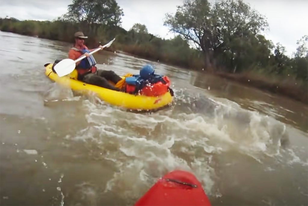Man in an inflatable boat encounters a hippo