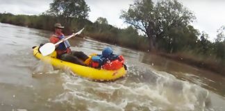 Man in an inflatable boat encounters a hippo