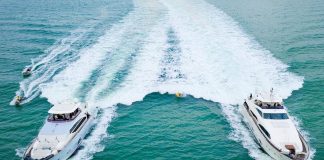 Dane Jackson surfs behind two 90-foot yachts