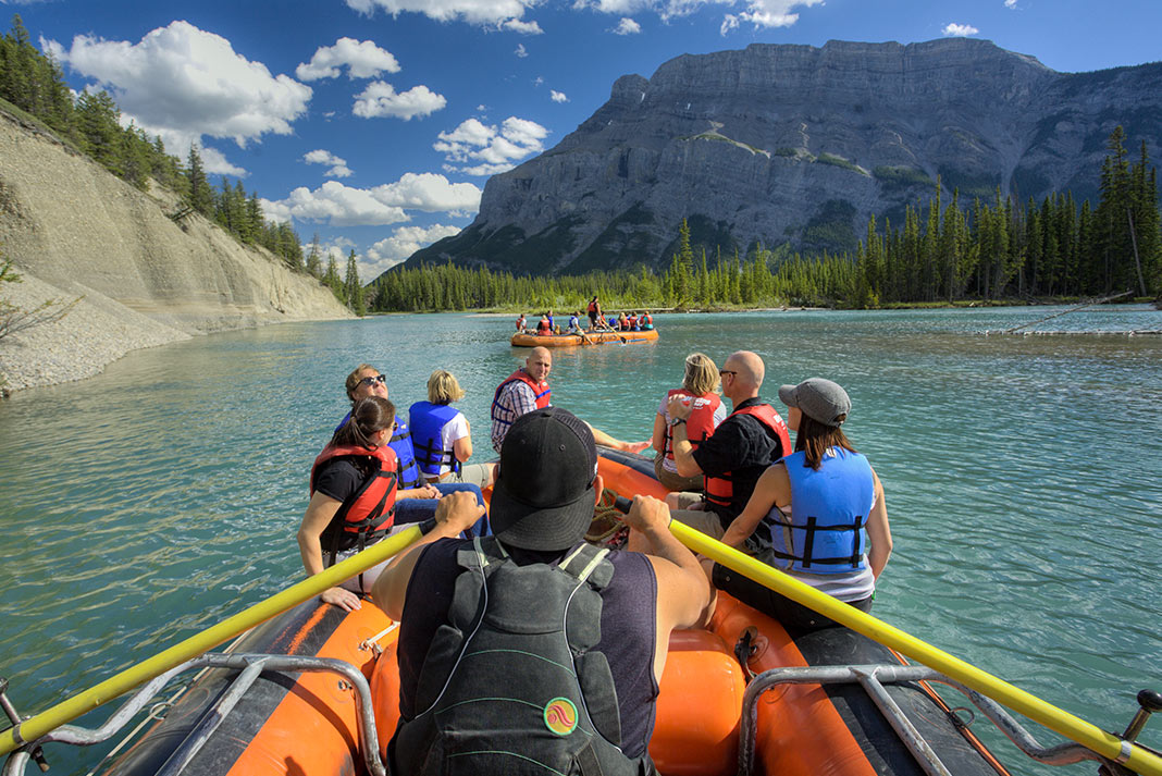 View from the back of a raft on the Bow River with mountain in background