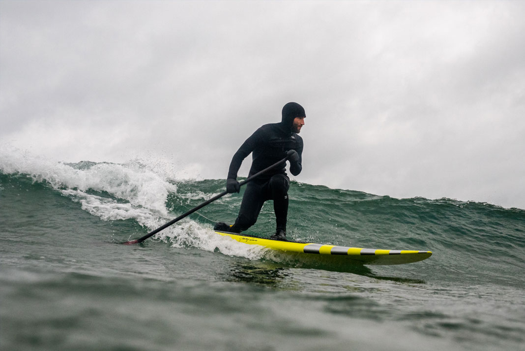 Person surfing on a wave on a paddleboard