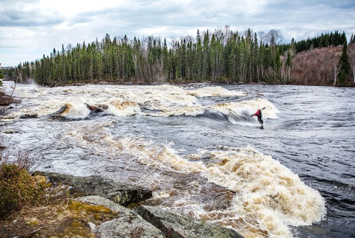 Whitewater kayaker riding a big wave.