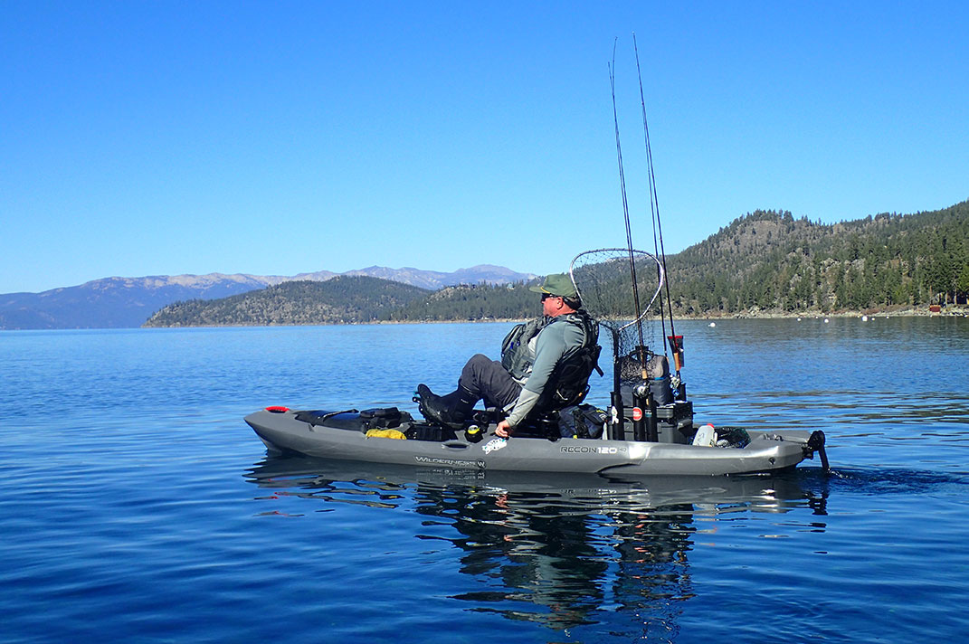Man pedals a fishing kayak on Lake Tahoe in California
