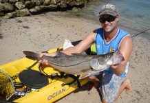 man holds up catch from kayak fishing in Costa Rica
