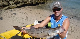 man holds up catch from kayak fishing in Costa Rica