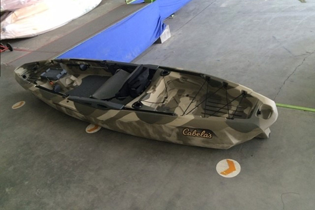 prototype of Cabela’s new Advanced Angler 120 fishing kayak sits on a warehouse floor