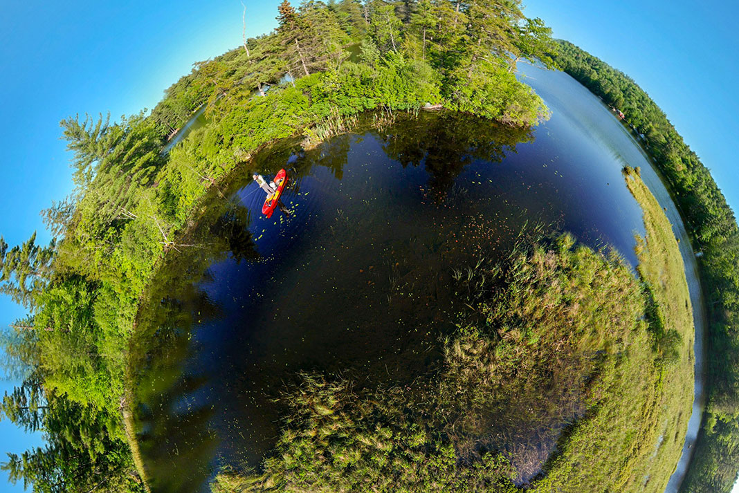 extreme fisheye shot of compact fishing kayak on a waterway