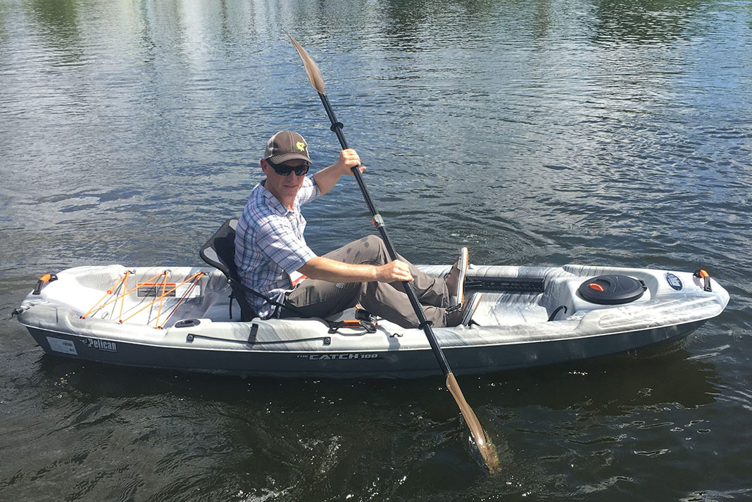 man paddles the Pelican Catch 100 fishing kayak