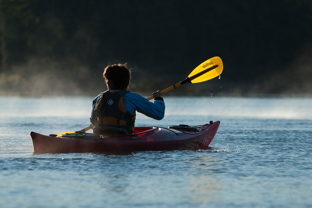 Woman paddles a touring kayak