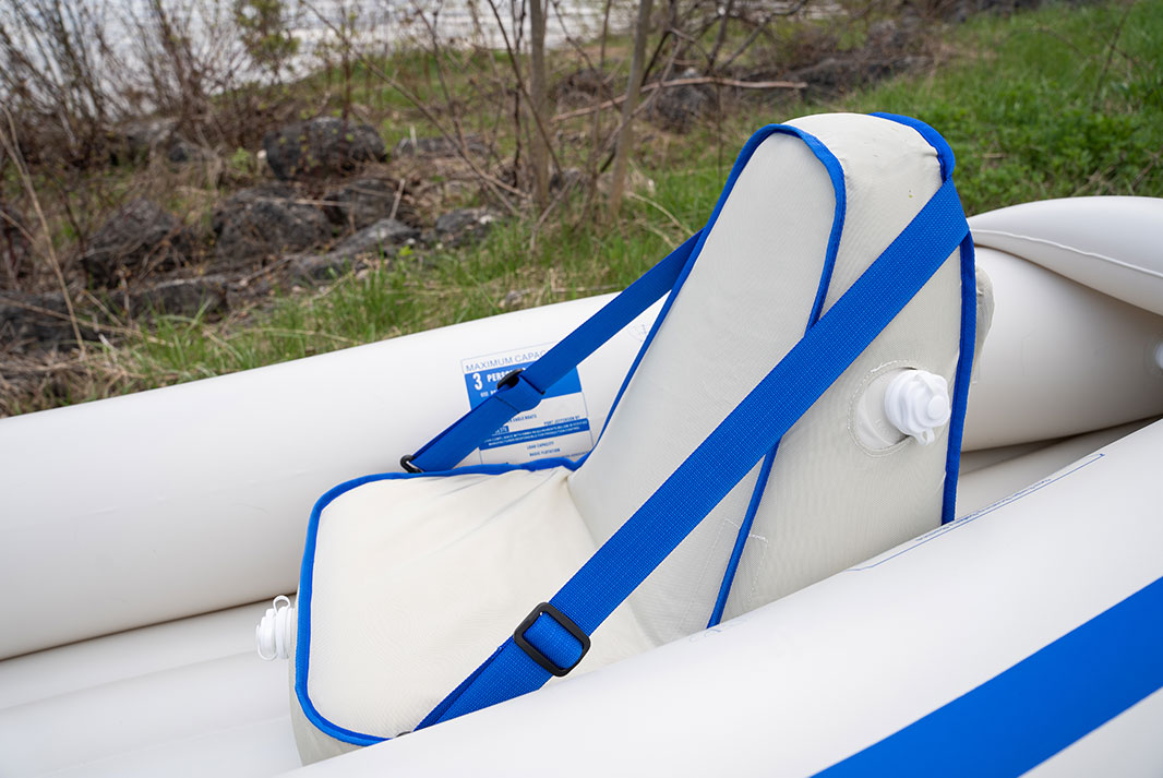 Blue and white inflatable kayak, with paddler on the water