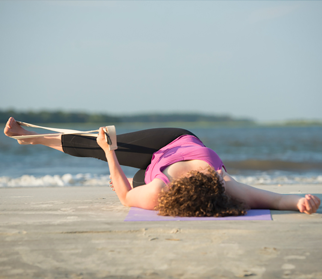 Woman lying on back with leg across body