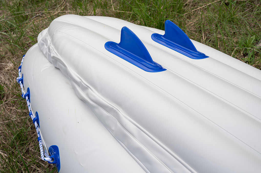 Blue and white inflatable kayak, with paddler on the water