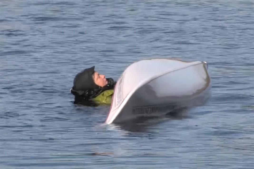 woman demonstrates a sea kayaking re-entry and roll, an important safety skill