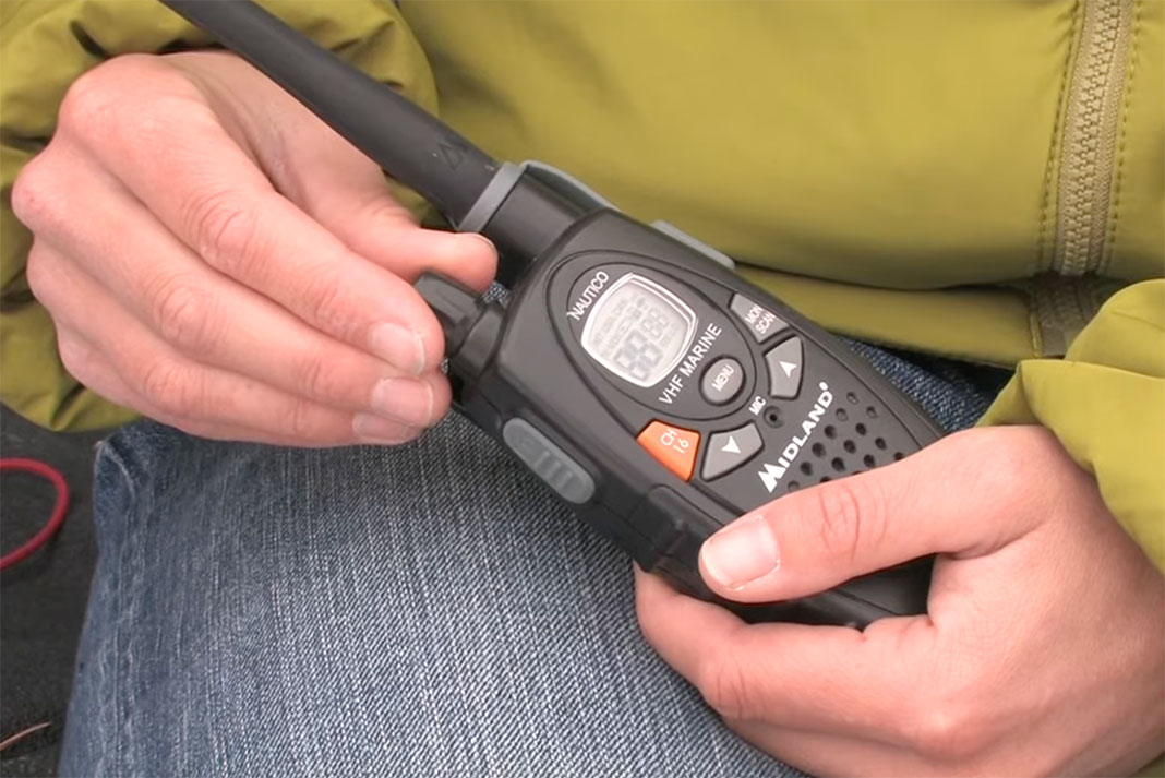 person demonstrates the use of a marine VHF radio