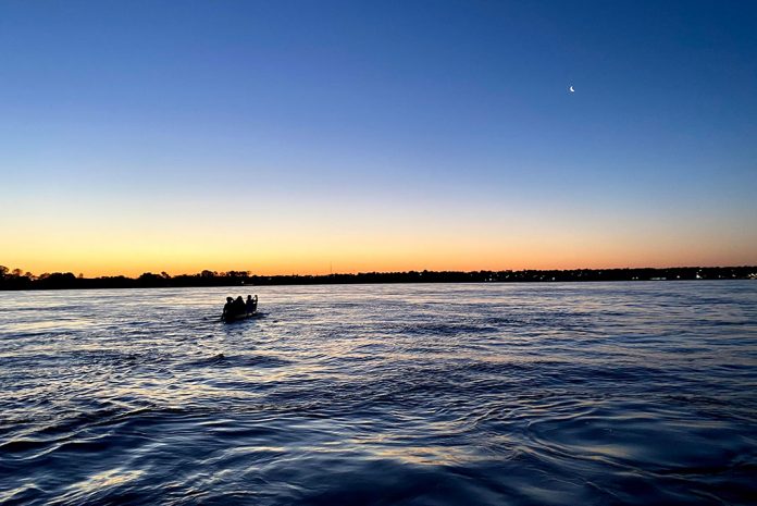 Canoe on lake silhouetted at sunset