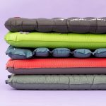 5 Best Sleeping Pads For Kayak And Canoe Camping Various colors of sleeping pads stacked on top of one another