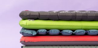 Various colors of sleeping pads stacked on top of one another