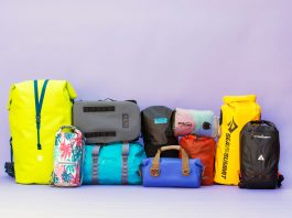 Drybags in a variety of sizes and colors stacked on one another.