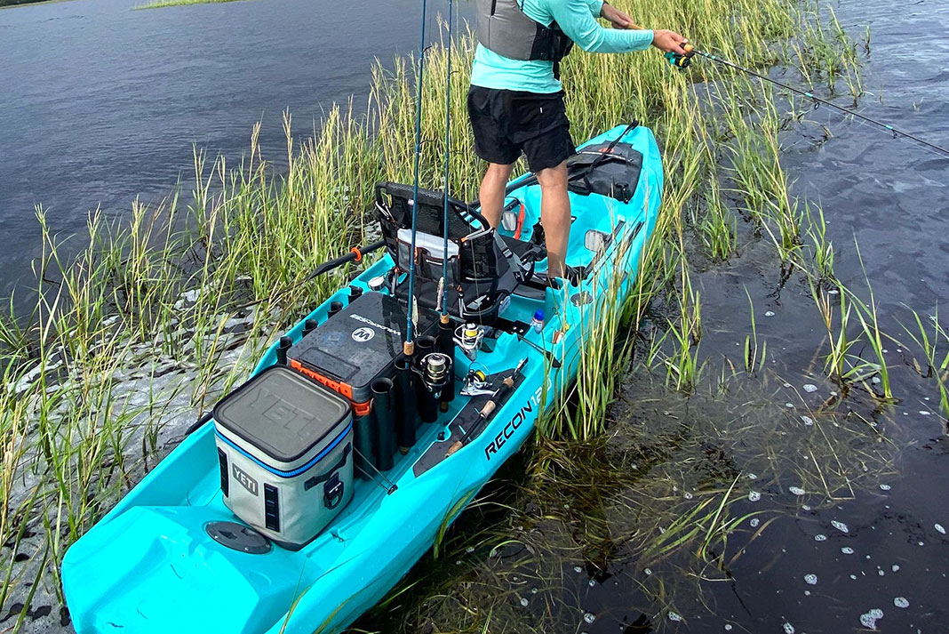 Angler fishes from a Wilderness Systems Recon kayak with a Yeti cooler in the back