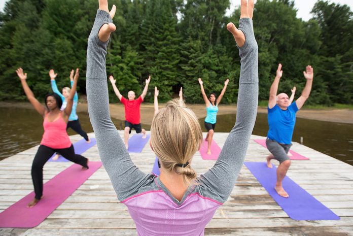 People on a dock doing yoga