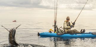 kayak angler wearing Hobie Polarized Hydro sunglasses while catching a fish
