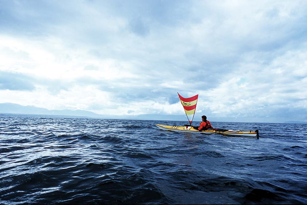 man uses a kayak sail while on the water