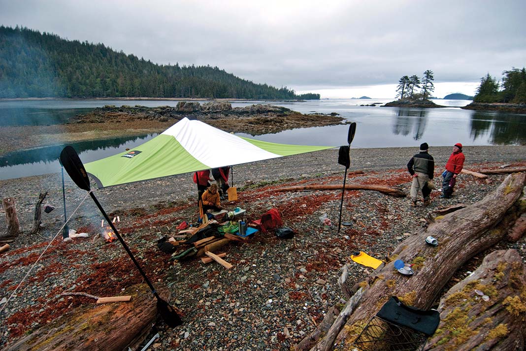 kayakers setup a tarp shelter while on a camping trip