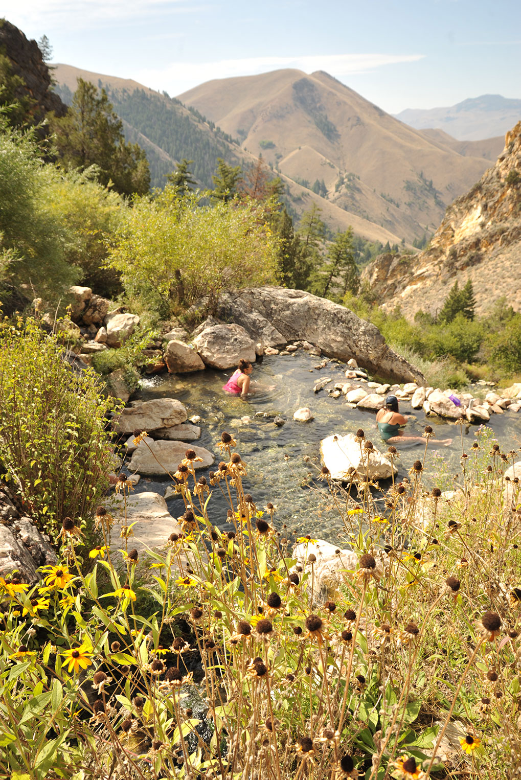Women sitting in natural hot spring in mountains