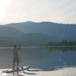 Inflatable Paddleboard Review: Red Paddle Co 11’3” Sport Man paddling toward mountains on paddleboard