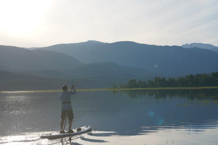 Man paddling toward mountains on paddleboard