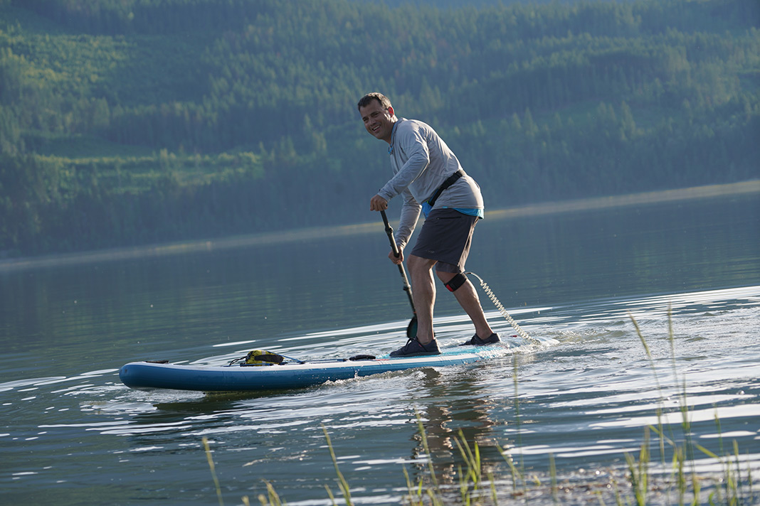 Man standing near back of paddleboard
