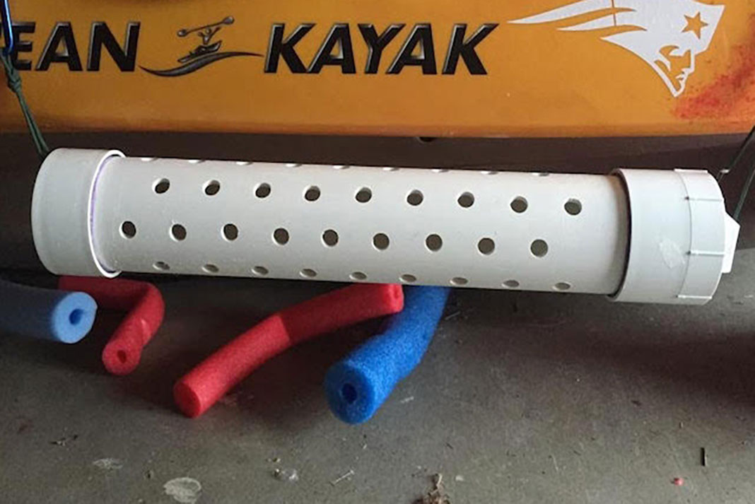 a white DIY live bait tube lies on the garage floor