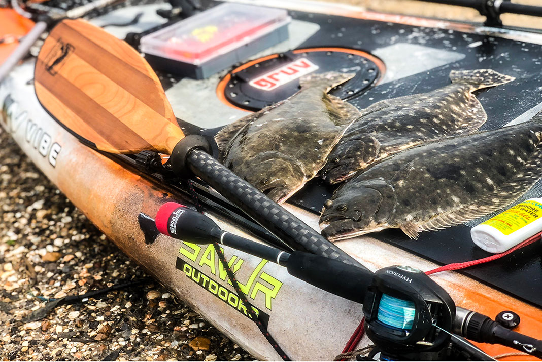 three flounder are laid out on a kayak after being caught on the Gulf Coast