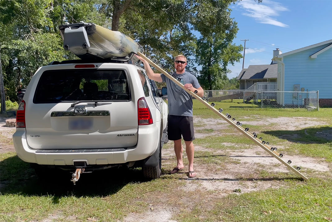 man demonstrates how to unload a kayak from his diy load assist