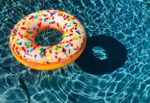 at inflatable tube decorated like a sprinkled donut floats in a pool