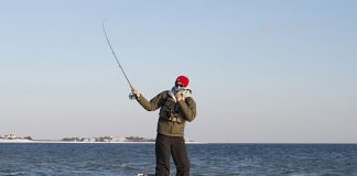 weekend warrior stands up and casts in cold weather while kayaking fishing