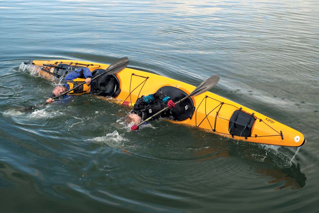 two kayakers demonstrate a tandem kayak roll