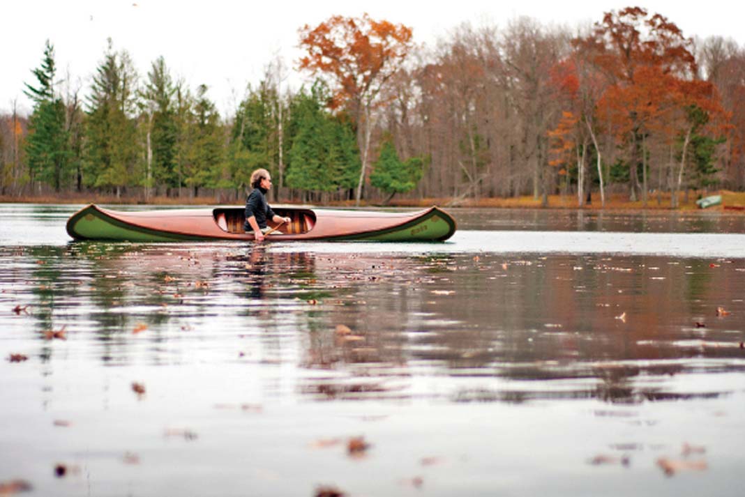 man paddles an antique courting canoe