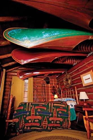 a collection of old-fashioned courting canoes stored among the rafters of a wood cabin