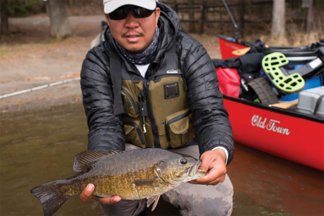Rex DeGuzman holds up his very first smallmouth bass, caught on the trip