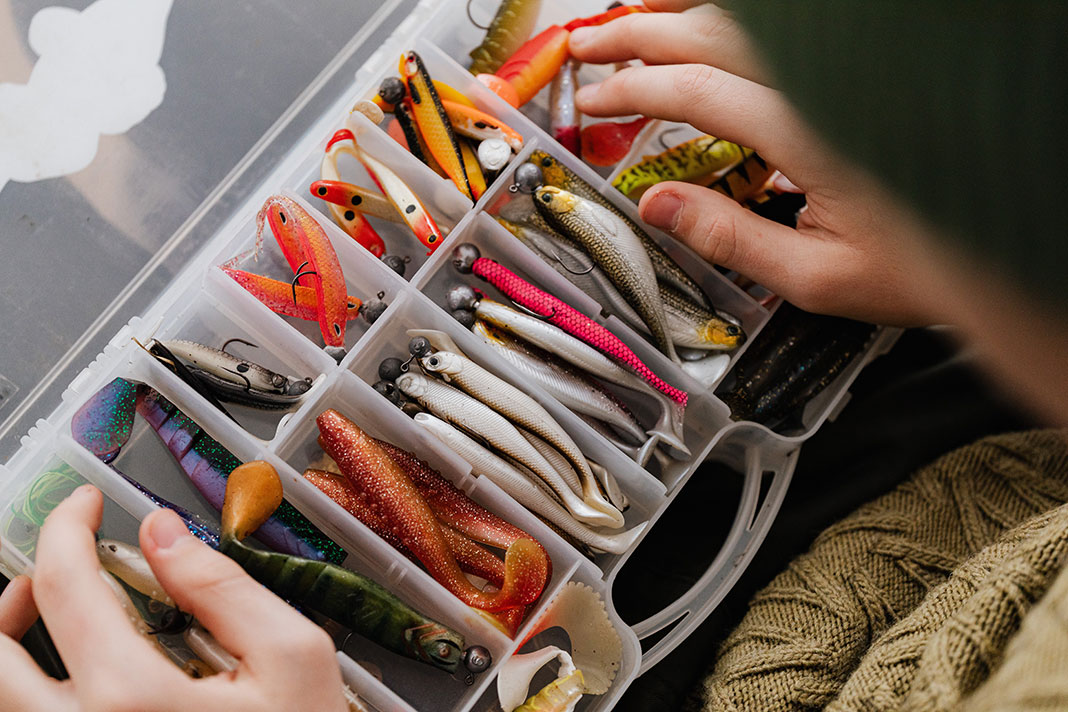 angler holds a tackle tray full of fishing lures