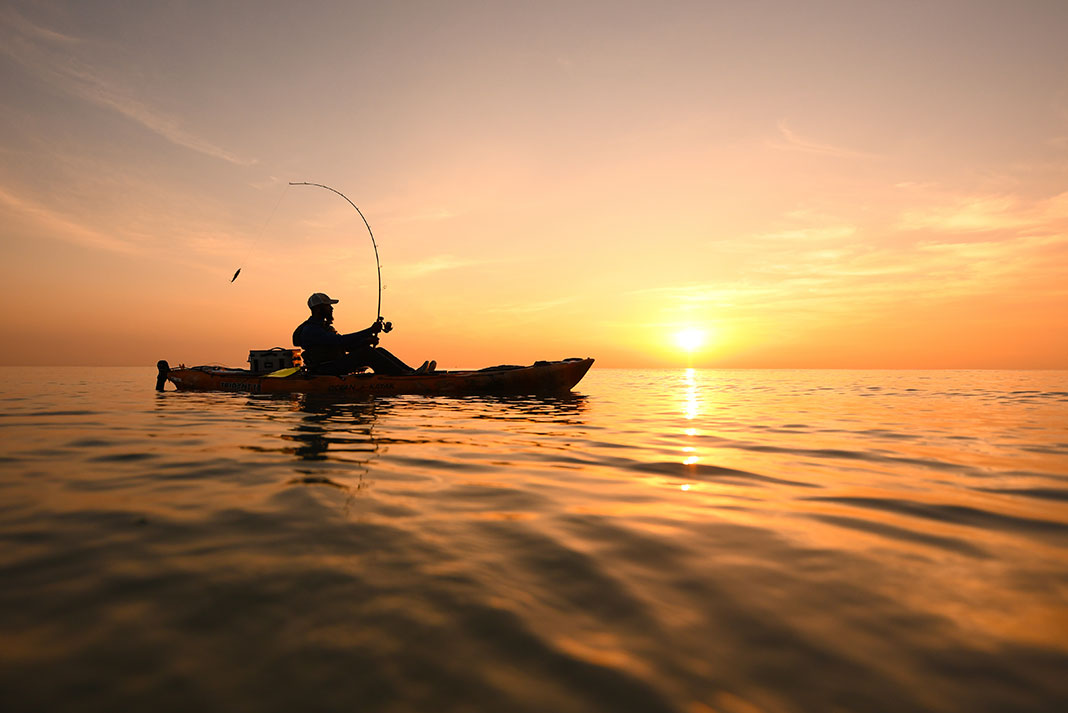 a kayak angler fishing in the dusk after leaving work with an excuse
