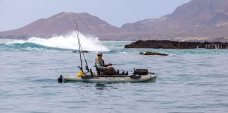 saltwater angler pedals in reverse on his fishing kayak