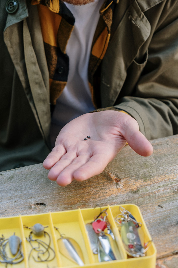 angler holds a pair of small fishing weights in his hand