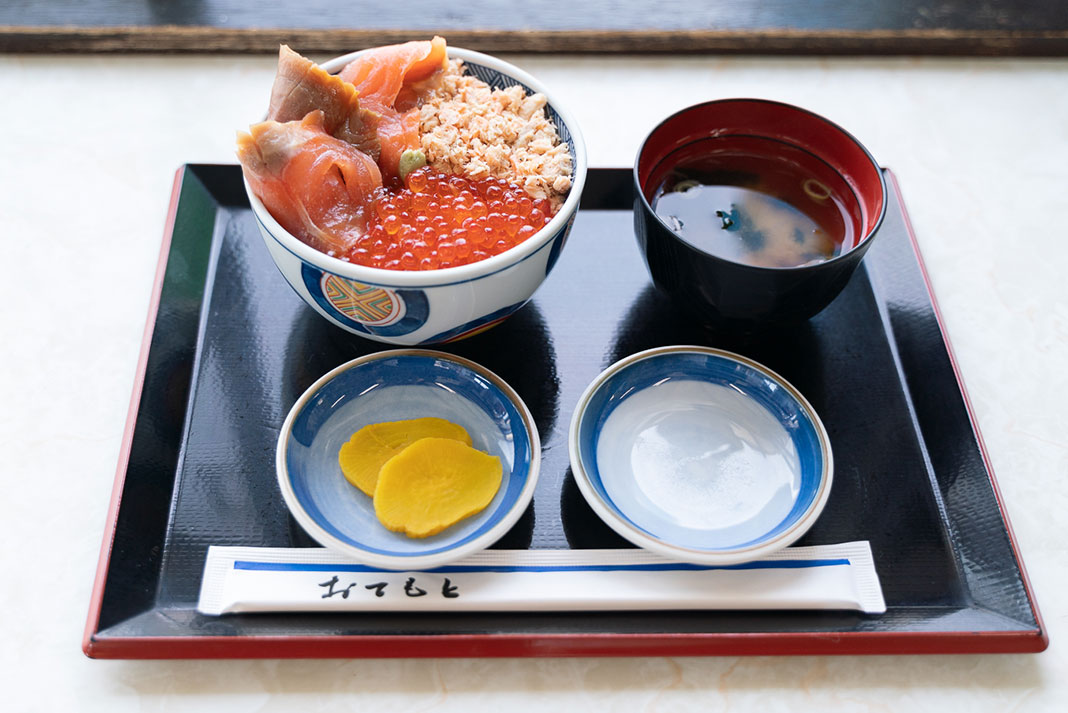Two bowls with seafood, two plates, and chopsticks package