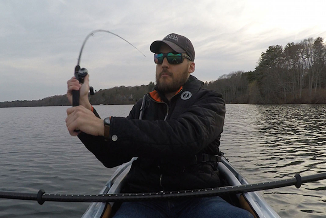 Man in a kayak winds up demonstrate how to cast a baitcaster