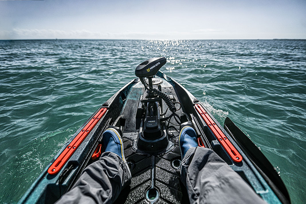 kayak angler uses feet to control a kayak trolling motor