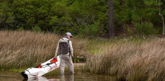 man pulls an Oru Inlet folding kayak from the water