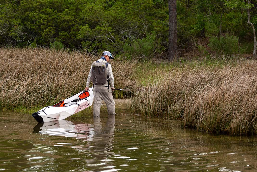 man pulls the Oru Inlet folding kayak from the water