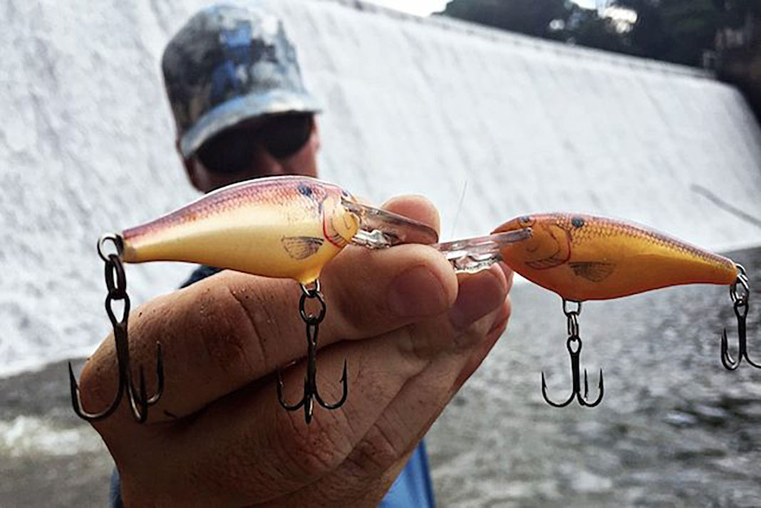Eric Boyd holds up two fishing lures that have been faded in the sun